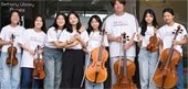Teens lined up holding stringed instruments.