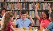 Kids sitting at a table in a library